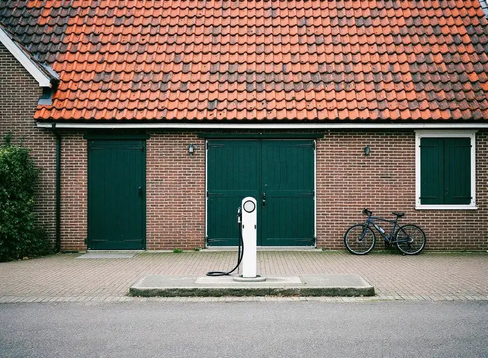 Eén eenvoudige witte pomp voor een oude bakstenen schuur met groene deuren, met een fiets tegen de muur